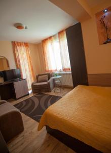 a hotel room with a bed and a chair at Guest house Lidia in Tsigov Chark
