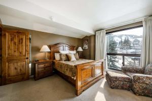 a bedroom with a bed and a window and a chair at Silver King by All Seasons Resort Lodging in Park City +150 photos
