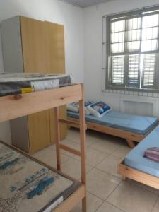 a room with three bunk beds and a window at Hostel Cachoeira in Porto Alegre