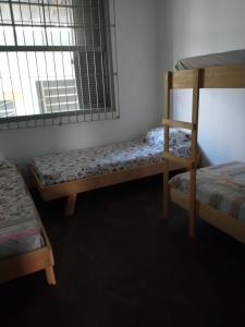 a bedroom with two bunk beds and a window at Hostel Cachoeira in Porto Alegre