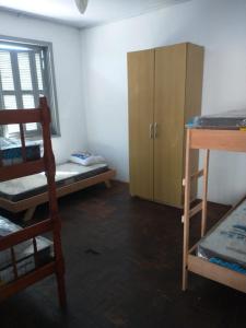 a room with two bunk beds and a wooden cabinet at Hostel Cachoeira in Porto Alegre