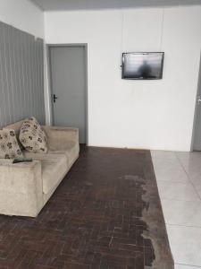 sala de estar con sofá y TV de pantalla plana en Hostel Cachoeira en Porto Alegre