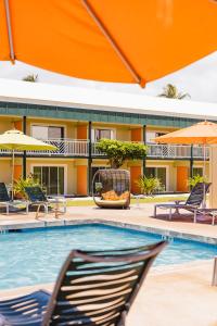 einen Pool in einem Hotel mit Stühlen und Sonnenschirmen in der Unterkunft Kauai Shores Hotel in Kapaa