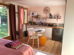 una pequeña cocina con mesa, mesa y sillas en Tiny-House sous les arbres et les oiseaux, 