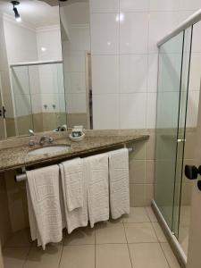a bathroom with a sink and a mirror and towels at Hotel Atlântico Tower in Rio de Janeiro