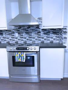 a kitchen with a stainless steel stove and white cabinets at WELCOME TO PREMIUM LIVING PLACE / 2 BEDROOMS SUITE in Innisfil