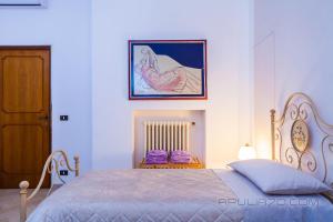 1 dormitorio con 1 cama y una foto en la pared en Apulia 70 Holidays, en Polignano a Mare