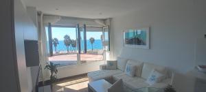 uma sala de estar com um sofá e vista para o oceano em Apartamento 5 EN PRIMERA LÍNEA DE PLAYA CON VISTAS AL MAR em Almeria