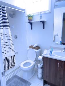 Baño blanco con aseo y lavamanos en WELCOME TO PREMIUM LIVING PLACE / 2 BEDROOMS SUITE, en Innisfil