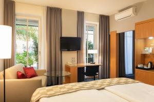 a hotel room with a bed and a couch and a table at Holiday Inn Vienna City by IHG in Vienna +37 photos