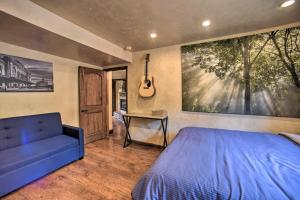 Un dormitorio con una cama azul y una guitarra en la pared en Homey Mtn View Escape 11 Mi to Garden of the Gods, en Cascade-Chipita Park