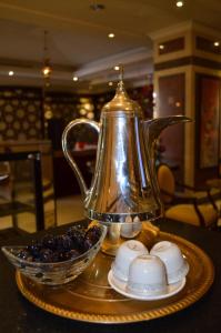 a tea kettle and a bowl of berries on a table at Rotana Al Mesk Hotel in Medina