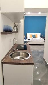a kitchen with a sink and a room with a bed at TRACK 60 - PRIVATE ROOMS GARIBALDI in Naples