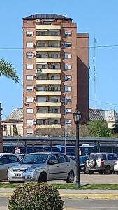 un edificio alto con coches estacionados frente a él en Vista Apart en Tigre