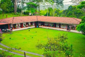 a building with a large green field in front of it at Villa Cristina - Casa Boutique in Pereira