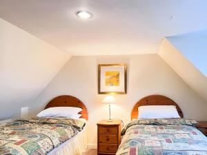 two beds in a attic room with two beds at Grieves Cottage in Arnisdale