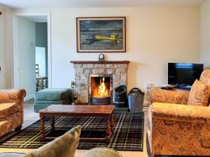 a living room with a fireplace and a couch at Grieves Cottage in Arnisdale