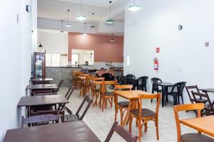 a dining room with wooden tables and chairs at Hotel Pousada Santa Maria in Aparecida