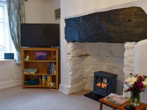 a living room with a fireplace and a television at Woodville in Porthmadog