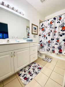 a bathroom with a toilet and a shower curtain at Huge Screened Patio That Overlooks Lake Buck, Near Famous Attractions!! in Orlando