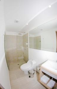 Baño blanco con aseo y lavamanos en Hotel Boutique Laureles Medellin (HBL) en Medellín