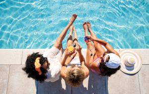 three women laying on the edge of a swimming pool at Sawmill Creek by Cedar Point Resorts in Sandusky