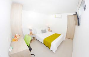 a white room with a bed and a tv at Hotel Boutique Laureles Medellin (HBL) in Medellín