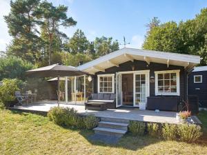 una piccola casa con portico e ombrellone di Holiday home Hasle VII a Hasle