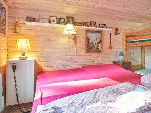 una camera con letto rosa su una parete in legno di Holiday home Hasle VII a Hasle