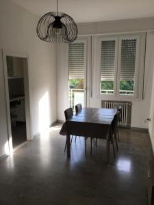 comedor con mesa, sillas y ventanas en Via Bellaria, en San Lazzaro di Savena