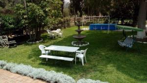 een tuin met een tafel en stoelen en een fontein bij casa campestre marina in Chaclacayo