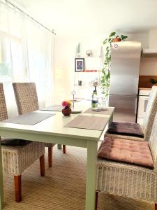 una cucina con tavolo, sedie e frigorifero di Apartment Souterrain Bühl Vimbuch Familie Bork a Bühl