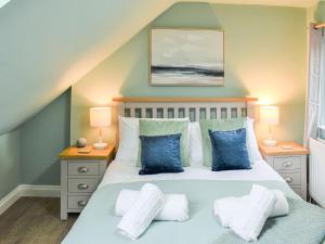 a bedroom with a bed with blue and white pillows at Ty Kinik in Llangollen