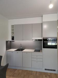 uma cozinha branca com armários brancos e um lavatório em Ruby studio 5min to Vantaa Airport and 20min to Helsinki center em Vantaa