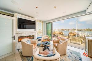 a living room with a fireplace and a large window at Beach House Steps from Balboa Ferry in Newport Beach