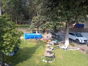 een groep mensen die op stoelen onder een boom zitten bij casa campestre marina in Chaclacayo