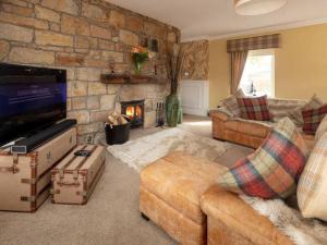 a living room with a couch and a fireplace at The Cottage At Briarlea in Larkhall