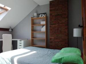 una camera da letto con un letto con cuscini verdi di -- Le Sanctuaire, à 50 mètres de la Gare -- ad Annecy