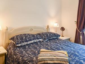 a bedroom with a bed with a blue comforter and pillows at The Old Sweetshop in Par