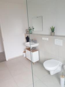 a white bathroom with a toilet and a sink at Ferienwohnung - Melina - in Winsen Aller +17 photos