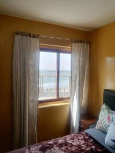 1 dormitorio con ventana y vistas a la playa en Hospedaje Restaurante El Hombre, en Puerto Chicama