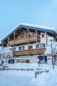 ein großes Gebäude mit Schnee davor in der Unterkunft Gästehaus Hanna Teifel in Reit im Winkl