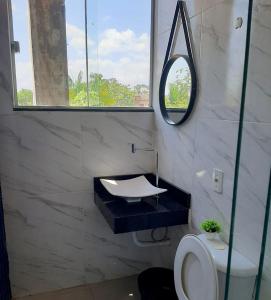 a bathroom with a sink and a mirror and a toilet at Casa no Centro (Orla de Marabá) in Marabá