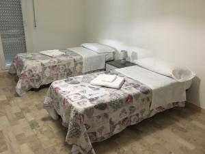 2 camas en una habitación con mesas y toallas en Via Bellaria, en San Lazzaro di Savena