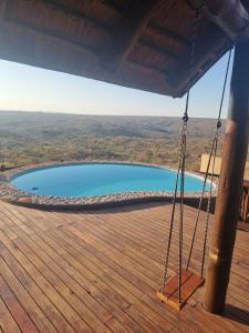 a hammock on a deck with a swimming pool at Sunset Private Game Lodge Mabalingwe in Warmbaths