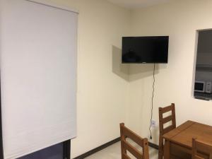 a room with a white wall with a television and a table at Apartamento céntrico 3 Edificio picazzo en Mercedes Uruguay in Mercedes