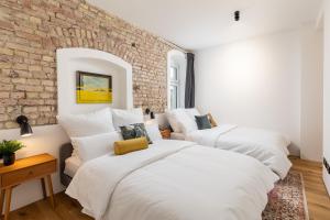 - 2 lits dans une chambre avec un mur en briques dans l'établissement 95sqm 4 room maisonette apt near center & PrenzlB, à Berlin