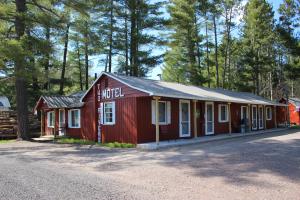 a red building on the side of a road at Two Rivers Motel and Cabins 