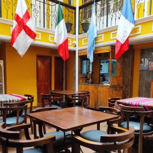 un restaurante con mesas de madera y banderas en la pared en Wake Up Hostel en La Paz