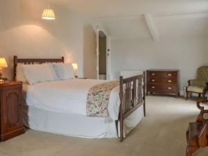 sypialnia z dużym białym łóżkiem i komodą w obiekcie East Monkton Farm Cottage w mieście Wick